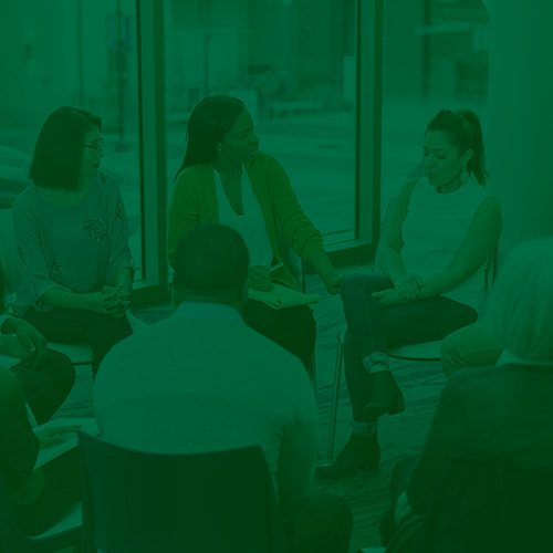 Grupo de pessoas sentadas em círculo participando de uma conversa em ambiente interno, simbolizando apoio emocional ou reunião sobre saúde mental.