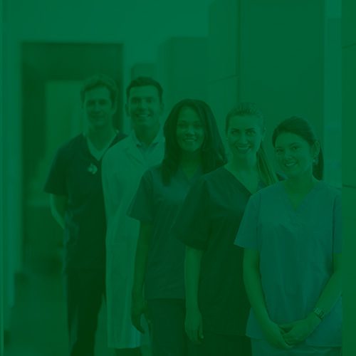 Profissionais da saúde usando jalecos e uniformes, alinhados e sorrindo em um ambiente clínico, com filtro verde sobre a imagem.
