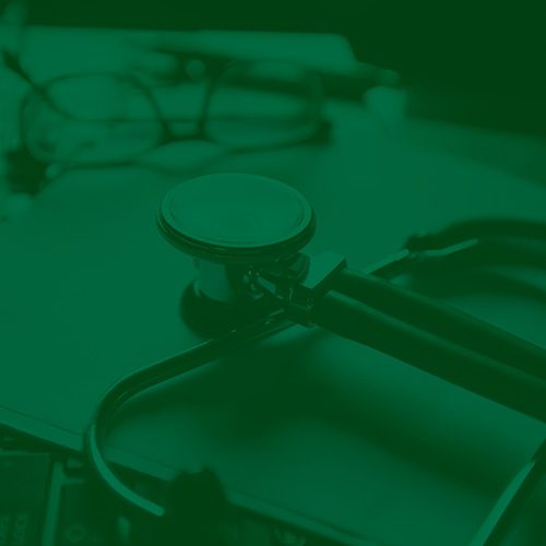 Estetoscópio sobre mesa com papéis e óculos ao fundo, representando atendimento médico e ambiente de consultório, com filtro verde escuro. Estetoscópio sobre mesa com papéis e óculos ao fundo, representando atendimento médico e ambiente de consultório, com filtro verde escuro.