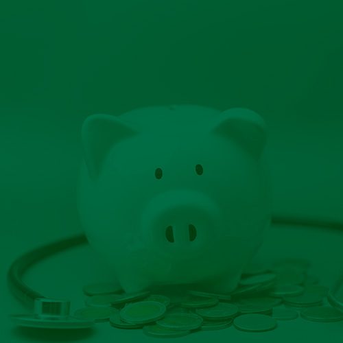 Cofre em formato de porquinho branco sobre moedas, com estetoscópio ao fundo, representando finanças e saúde.