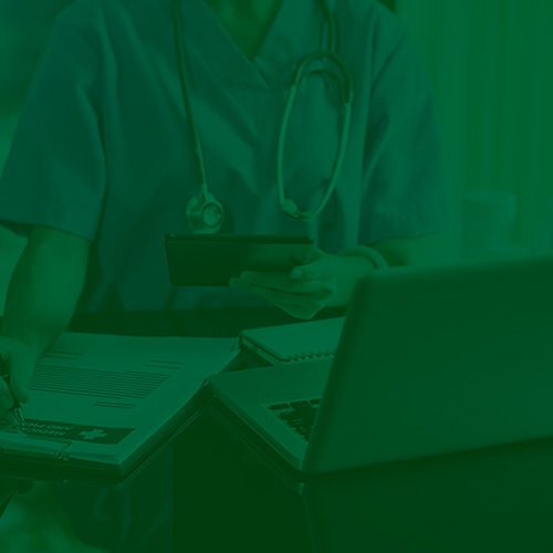Pessoa vestindo jaleco médico aparece com estetoscópio, analisando documentos ao lado de um notebook e segurando um celular.