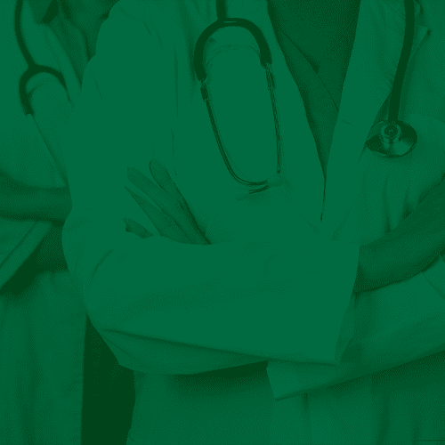 Profissionais de saúde com jalecos brancos e estetoscópios cruzam os braços, simbolizando equipe médica e atendimento especializado.