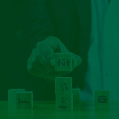 Mão posicionando bloco com ícone de família sobre outros cubos de saúde, simbolizando organização e cuidados essenciais.